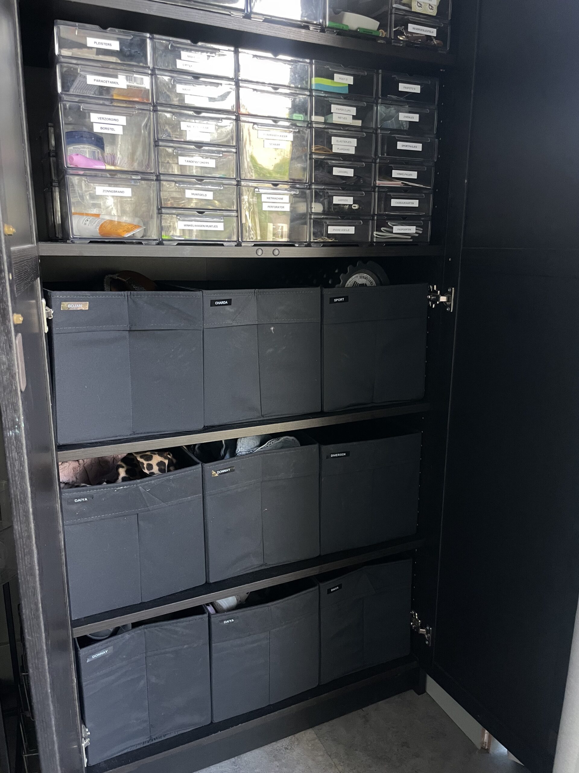 Open kast bij de achterdeur met voor ieder gezinslid een eigen bak