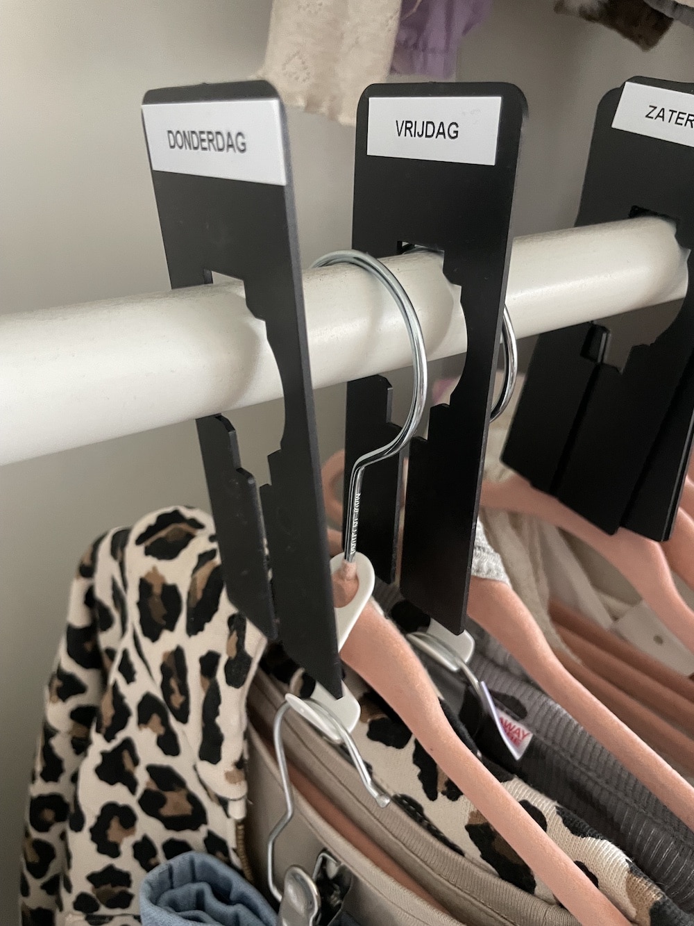 Complete outfit aan een hanger met een kledinghaakje voor de broek