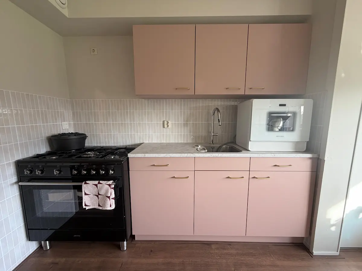 Kleine keuken met zes kastjes en twee lades, elk met een vaste functie