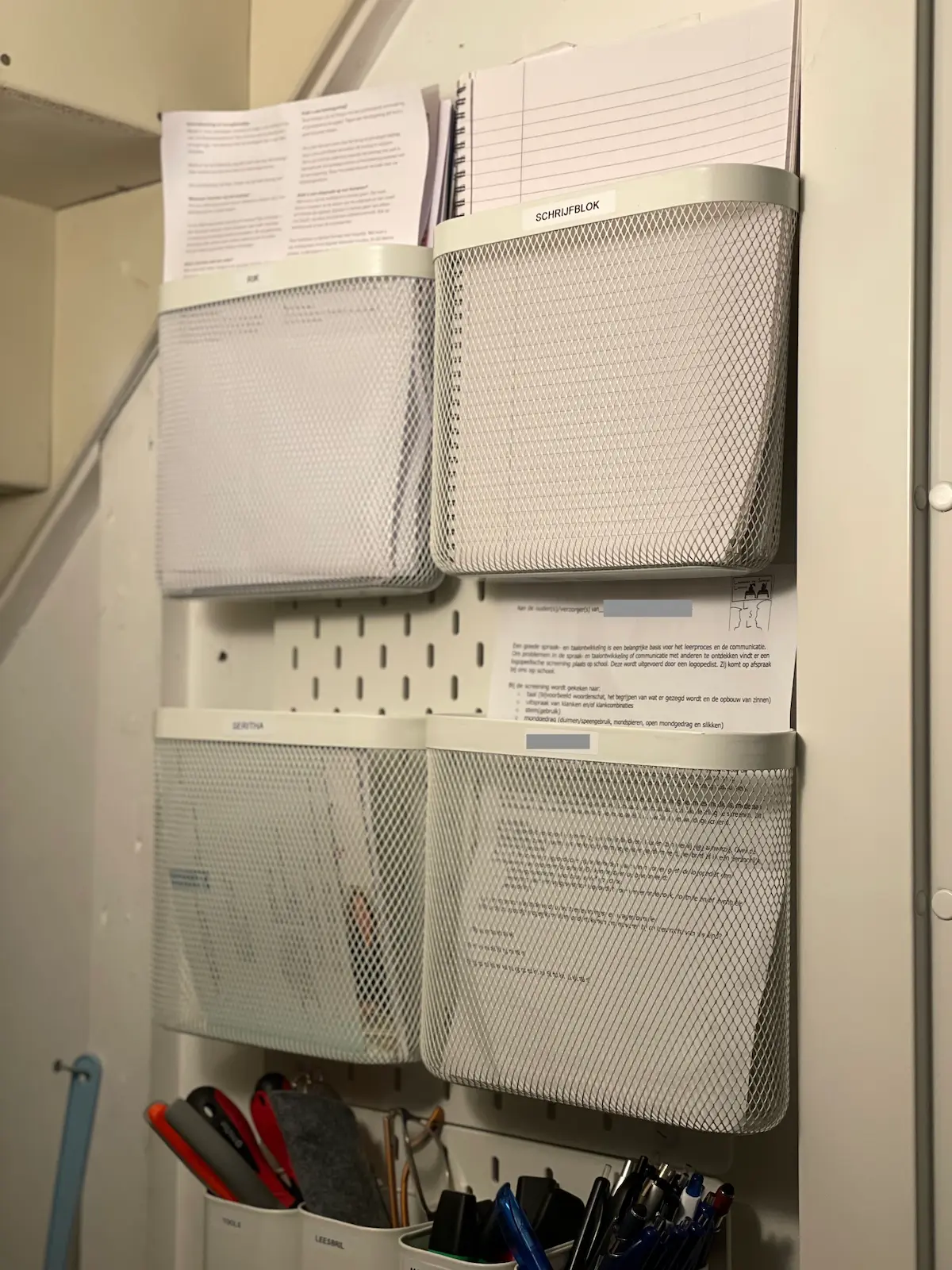 Poststation op een Skadis-bord met een postvakje per gezinslid